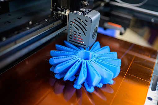 Close-up of plastic fan propeller 3D printing process.